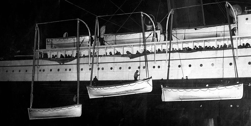 Passengers and survivors stare the Titanic's boats being loaded in the RMS Carpathia